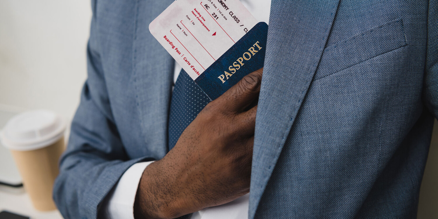 Viajante de terno guardando passaporte com cartão de embarque
