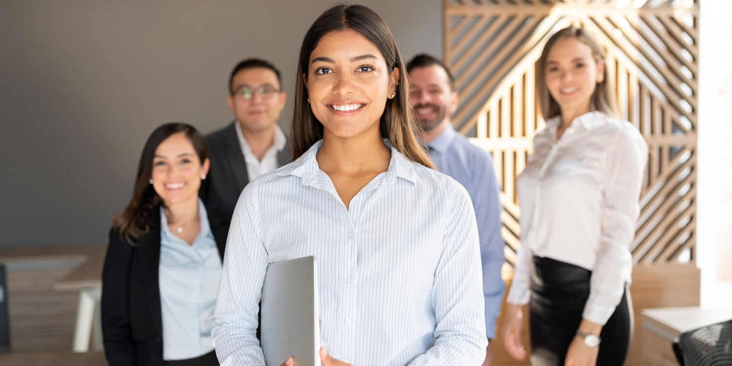 Trabalhadora sorridente com colegas de equipe no escritório