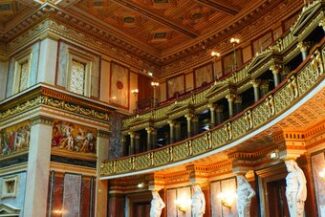 Interior ornamentado de salão legislativo, representando acompanhamento do processo legislativo