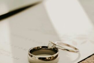 Alianças de casamento sobre um documento, simbolizando a dissolução do vínculo conjugal