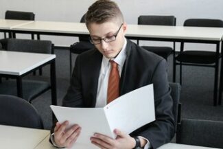 Servidor lendo documento formal sozinho em sala, representando processo administrativo disciplinar