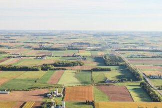 Vista aérea de propriedades rurais divididas em talhões, representando a regularização fundiária