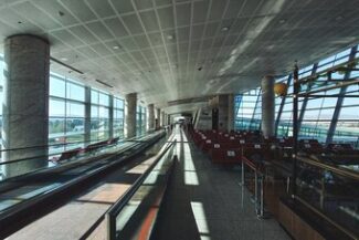 Vistos e Regularização de Estrangeiros Corredor com esteira rolante em terminal de aeroporto moderno, simbolizando o processo de vistos e regularização de estrangeiros