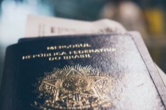 04-regularizacao-migratorio.jpg Passaporte da República Federativa do Brasil em mãos, simbolizando a regularização de estrangeiros no país