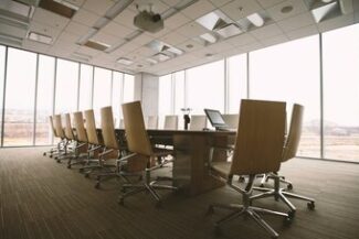 Sala de reunião corporativa vazia com mesa de madeira, simbolizando estruturação de holding familiar