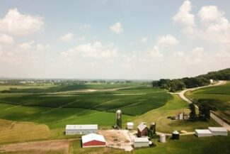 Vista aérea de propriedade rural completa com galpões e silos, representando o planejamento e holding rural