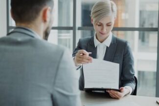 Profissional entregando documento em reunião, representando assessoria trabalhista empresarial