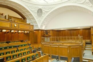 Sala de audiência vazia com bancada de madeira, representando cobrança judicial