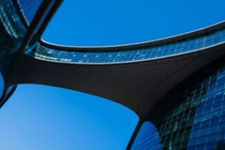 Vista de baixo de arquitetura moderna de vidro, representando estruturação societária